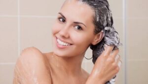 Женщина моет волосы в душе