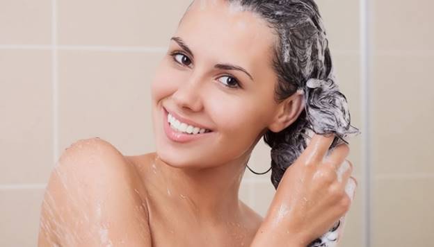 Женщина моет волосы в душе