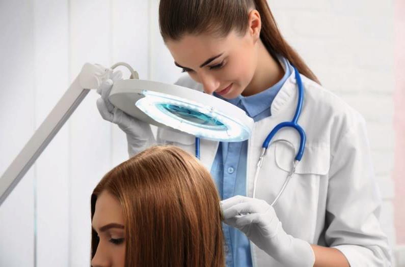 Трихолог проводит обследование кожи головы