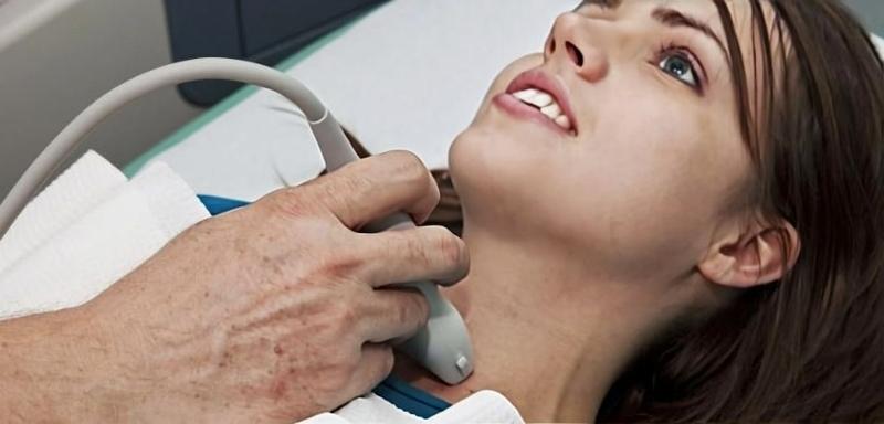 Пациентка проходит УЗИ щитовидной железы у врача