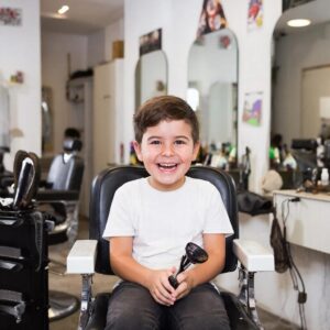 Ребёнок улыбается во время стрижки в парикмахерской