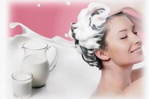 Девушка моет голову молочными средствами для ухода