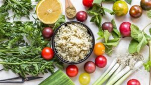 Овощи, крупы, зелень и тарелка каши — продукты, богатые полезными жирами и витаминами для волос