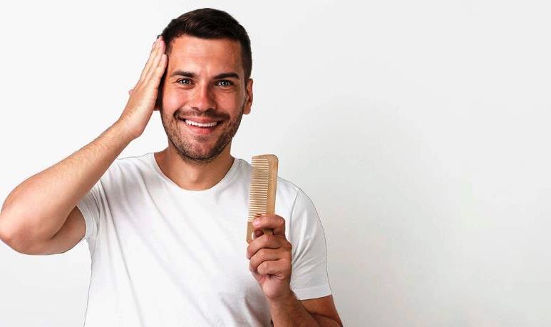 Мужчина улыбается и держит расческу