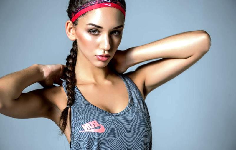 Спортивная девушка поправляет волосы перед тренировкой