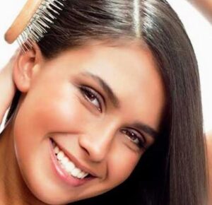 Девушка расчёсывает блестящие гладкие волосы